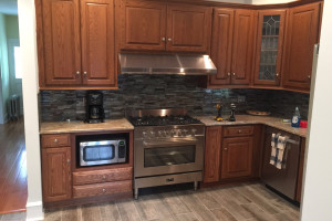 We added cabinets on left and right of owners new stove. Installed backsplash & New tile flooring.
